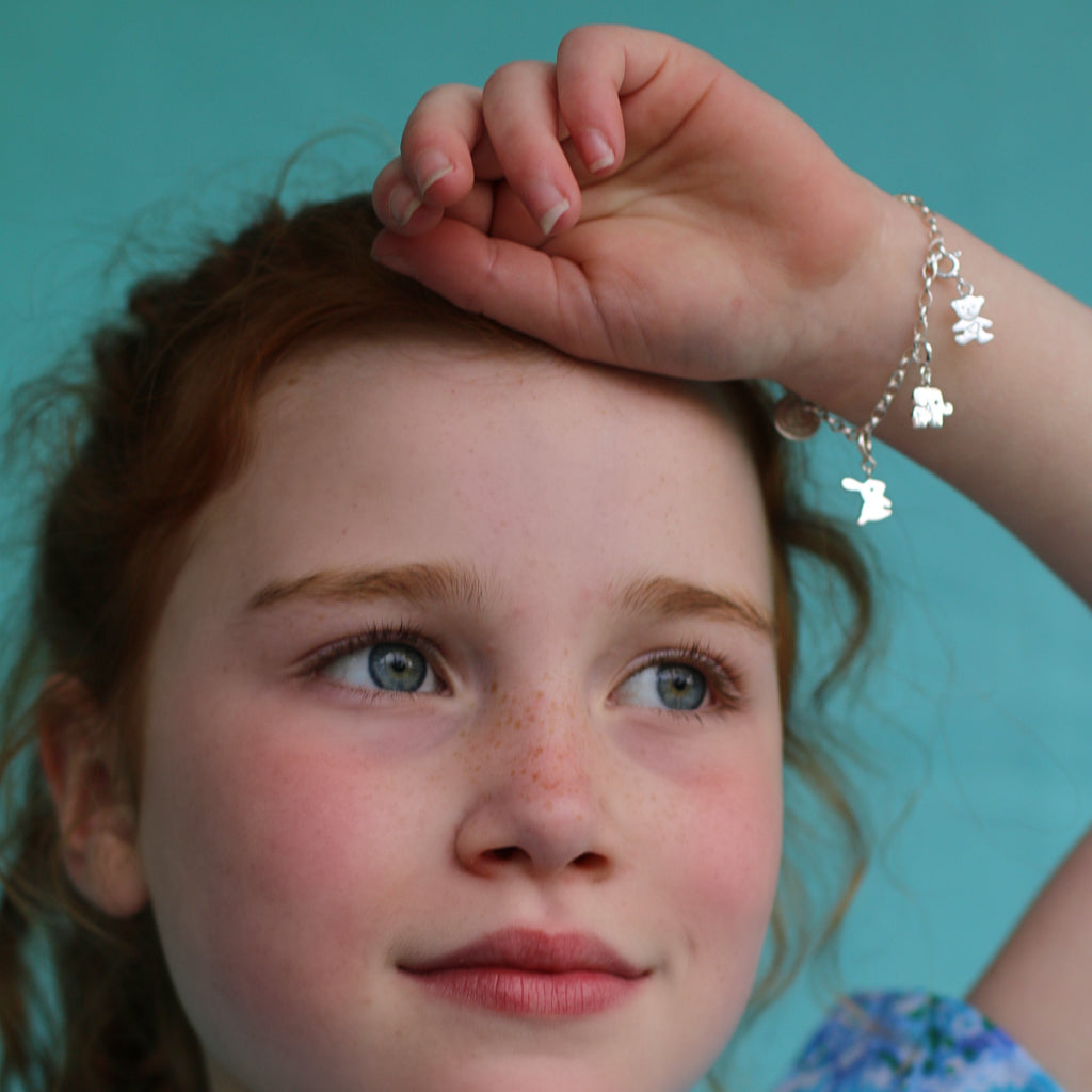 Girl wearing children's elephant charm on classic children's charm bracelet